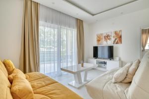 a living room with a couch and a tv at The Golden Luxury complex - Central and Seaboard in Kotor