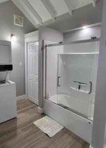 a bathroom with a shower with a glass enclosure at Olde Foundry Apt in Pictou