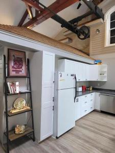 a kitchen with a white refrigerator and a shelf at Olde Foundry Apt in Pictou