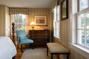 a bedroom with a bed and a dresser and windows at The Griswold Inn in Essex