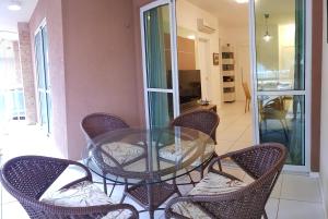a glass table and chairs on a balcony at PALM BEACH Porto das Dunas, apartamento todo climatizado TÉRREO a 350 metros Beach Park in Aquiraz