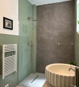 een badkamer met een groot bad en een douche bij Caves Garden in Bari