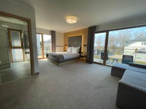 a bedroom with a bed and a couch and windows at Sea Resort 1 & Spa in Władysławowo +121 photos