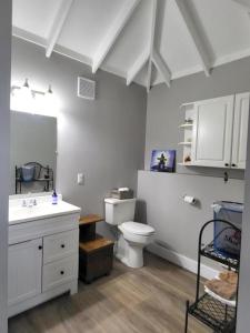 a white bathroom with a toilet and a sink at Olde Foundry Apt in Pictou