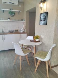 - une cuisine et une salle à manger avec une table et des chaises dans l'établissement Metekhi Apartments, à Tbilissi