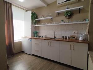 une cuisine avec des placards blancs et un comptoir dans l'établissement Metekhi Apartments, à Tbilissi