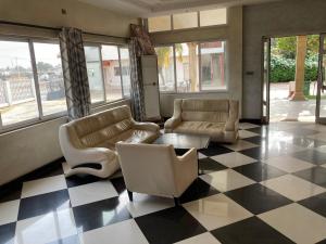 ein Wohnzimmer mit Sofas und einem karierten Boden in der Unterkunft Hotel Bel Azur Grand-Popo in Nicouécodji