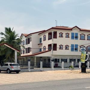 een auto geparkeerd voor een groot gebouw bij Hotel Bel Azur Grand-Popo in Nicouécodji