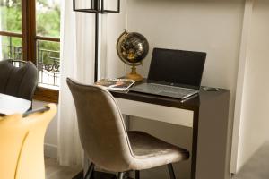 a laptop computer sitting on a desk with a chair at My Evening Break- Appartement cosy proche Disney et Paris in Noisy-le-Grand