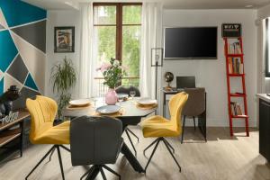uma sala de jantar com uma mesa e cadeiras amarelas em My Evening Break- Appartement cosy proche Disney et Paris em Noisy-le-Grand