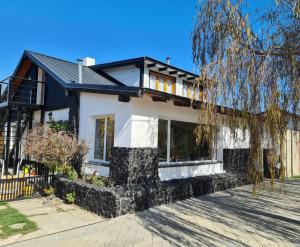 a white house with a black roof at Victoria in Esquel