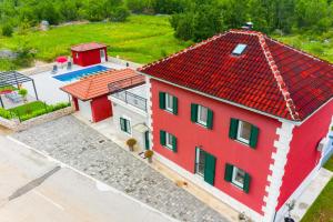 an overhead view of a red house with a pool at Villa Rubin in Slivno