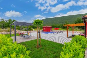 a playground with a swing set and a house at Villa Rubin with heated pool in Slivno +39 photos