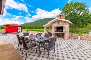 a patio with a table and a fireplace at Villa Rubin with heated pool in Slivno