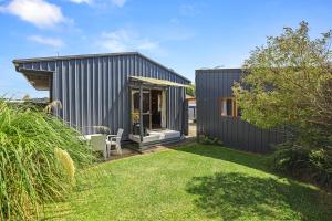 a small black house with a grass yard at Cosy Central Cottage in Rotorua