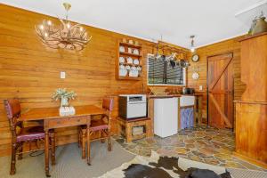 a kitchen with wooden walls and a table and a stove at Cosy Central Cottage in Rotorua
