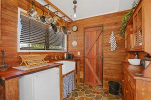 a kitchen with wooden walls and a counter with a sink at Cosy Central Cottage in Rotorua