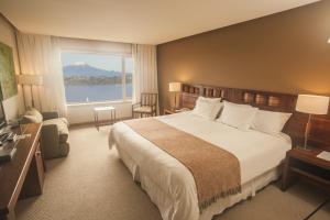 una camera d'albergo con un letto grande e una finestra di Wyndham Puerto Varas Pettra a Puerto Varas