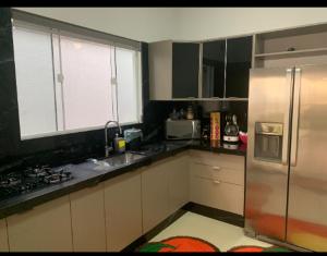 a kitchen with a stainless steel refrigerator and a window at Casa aconchegante in Sinop