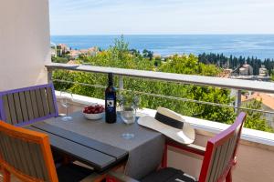 a table with a bottle of wine on a balcony at SunSpot Apartment - beautiful view with big garden, free parking, central in Dubrovnik