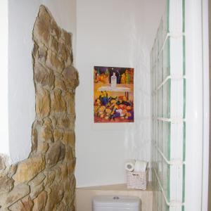 a bathroom with a stone wall next to a toilet at Armaño Rural in Tama