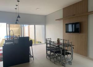 a living room with a table and chairs and a tv at Casa aconchegante in Sinop