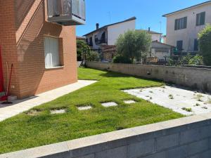 um quintal relvado ao lado de um edifício de tijolos em Casa Anna em Rapolano Terme