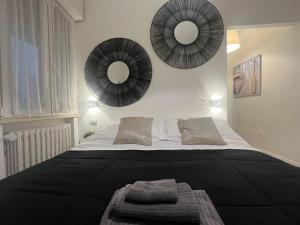 una camera da letto con un letto con due specchi sul muro di Appartamenti Mar y Sol a Gabicce Mare