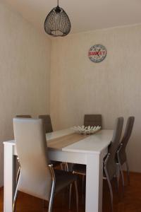 a dining room with a white table and chairs at Apartmani Mia in Jadranovo +43 photos