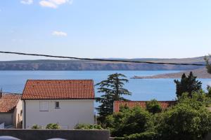 a white house with a view of the water at Apartmani Mia in Jadranovo