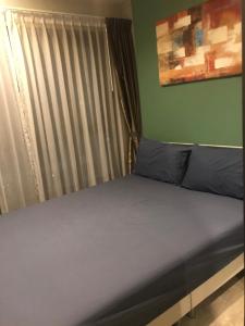 1 cama con almohadas azules en una habitación con ventana en The base central for family by bobby, en Pattaya central