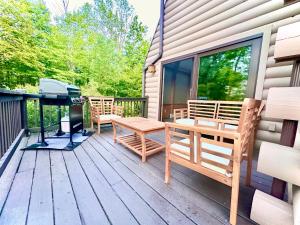 a deck with benches and a grill on a house at Big Bear Cabin in Corning