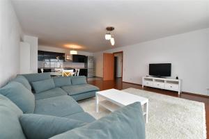 a living room with a blue couch and a tv at Apartament LUX 1 Mai Pod in Bucharest