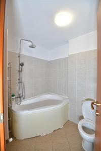 a bathroom with a white tub and a toilet at Apartament LUX 1 Mai Pod in Bucharest +15 photos