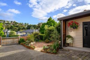 Macquarie Street Stable في هوبارت: منزل مع حديقة عليها زهور على الباب