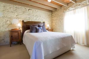 a bedroom with a bed and a stone wall at Macquarie Street Stable in Hobart