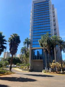a tall building with palm trees in front of it at Promoção - Flat em Brasília in Brasilia