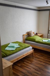 2 camas en una habitación con sábanas verdes en Zimmervermietung Familie Schuster, en Wusterhausen