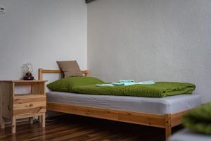 Una cama con una manta verde encima. en Zimmervermietung Familie Schuster, en Wusterhausen