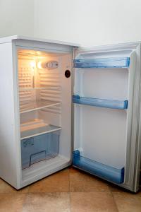 an empty refrigerator with its door open in a kitchen at Zimmervermietung Familie Schuster in Wusterhausen