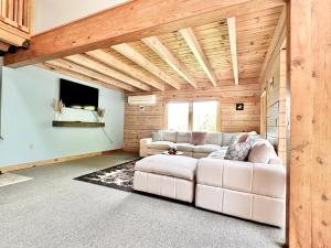 a living room with a white couch and a tv at Big Bear Cabin in Corning