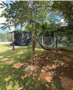 a hammock is tied to two trees in a yard at Pousada Família Bueno in Monte Alegre do Sul