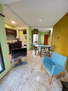 a living room with a tv and a table and chairs at Departamento Terruños in Tunuyán