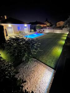 a backyard at night with a swimming pool at Tony's house with private pool, garden and parking in Zadar
