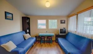 una sala de estar con sofás azules y una mesa. en Domek na Mazurach, en Mrągowo