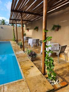a patio with a table and a swimming pool at Kite and Dreaming House in Cumbuco