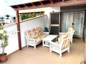 een terras met twee stoelen en een tafel op een balkon bij Casa Teahupoo in Cotillo