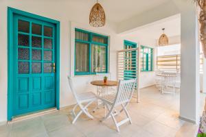 a room with a blue door and a table and chairs at Avlu Otel Palamutbükü in Datca