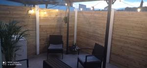 un patio con 2 sedie e una recinzione in legno di Dungarvan Studio a Kilkenny