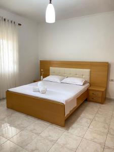 1 dormitorio con 1 cama grande con sábanas blancas en Marl's Home en Berat